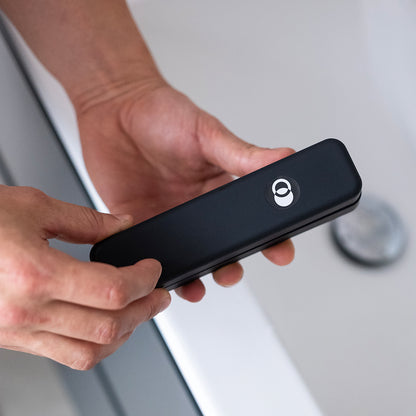 Person holding a ZENLUCA Hair Growth Dermaroller case in the bathroom